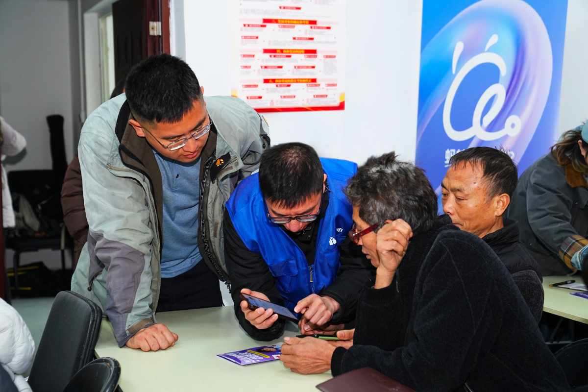 在蓝马甲志愿者的帮助下，村医们认真学习如何使用蚂蚁阿福app。